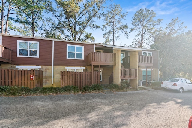 view of front of house with a balcony and fence