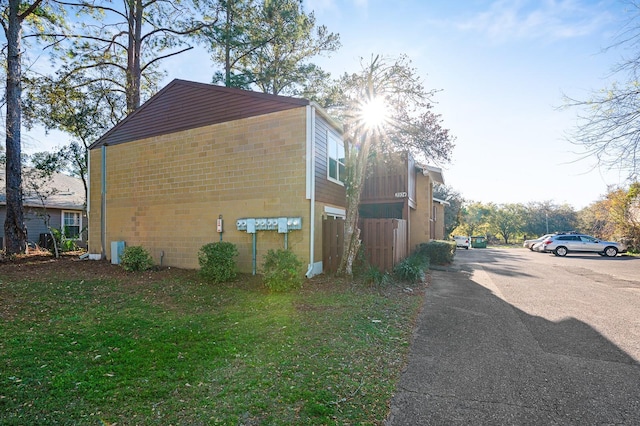 view of side of home with brick siding and a yard