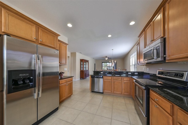 kitchen with an inviting chandelier, kitchen peninsula, pendant lighting, light tile patterned floors, and appliances with stainless steel finishes