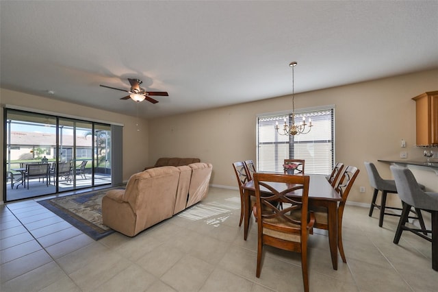 dining room with plenty of natural light, light tile patterned floors, and ceiling fan with notable chandelier