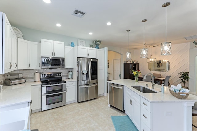 kitchen with hanging light fixtures, sink, an island with sink, appliances with stainless steel finishes, and white cabinetry