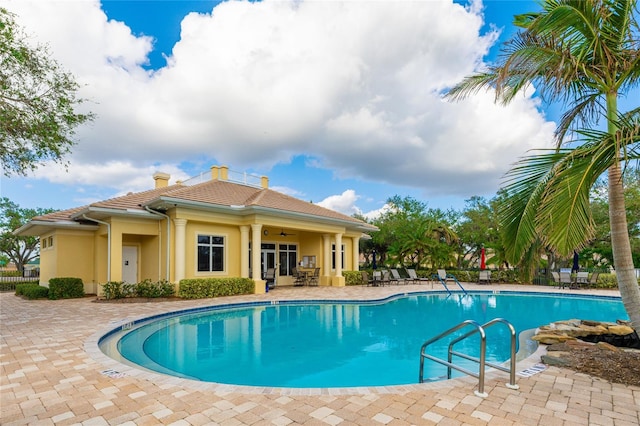 view of swimming pool featuring ceiling fan and a patio