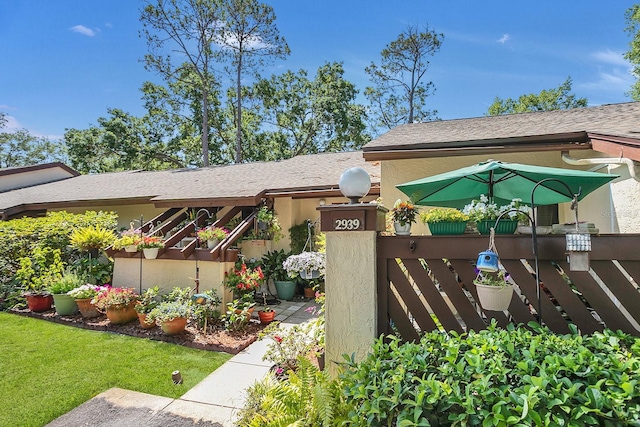 view of front of house with fence and stucco siding