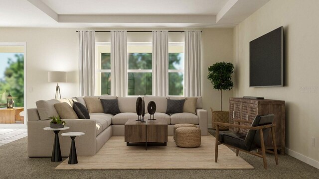 carpeted living room featuring a tray ceiling and a healthy amount of sunlight