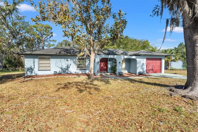 ranch-style house with a garage and a front lawn