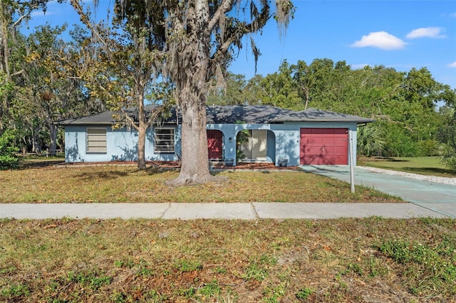 ranch-style home featuring a front lawn and a garage