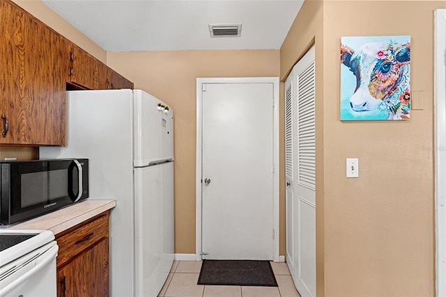 kitchen featuring light tile patterned floors and electric stove