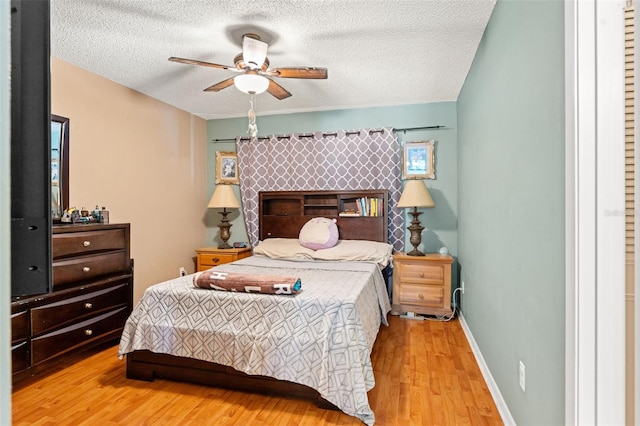 bedroom featuring ceiling fan, a textured ceiling, and light hardwood / wood-style flooring