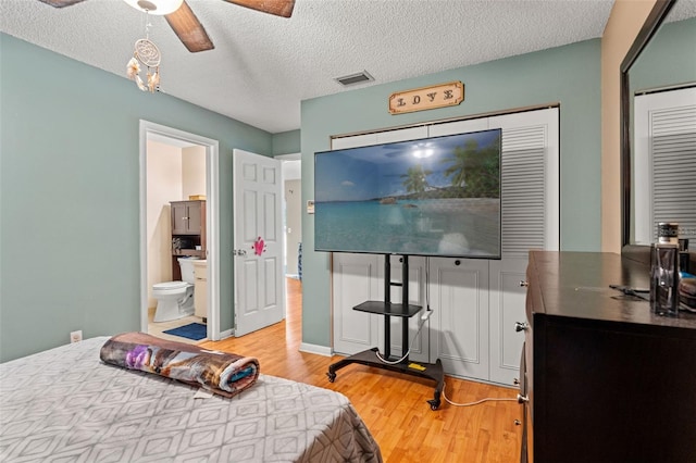 bedroom with a textured ceiling, hardwood / wood-style flooring, and ceiling fan