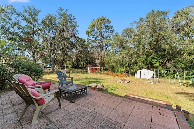 view of patio / terrace featuring a fire pit and a storage shed