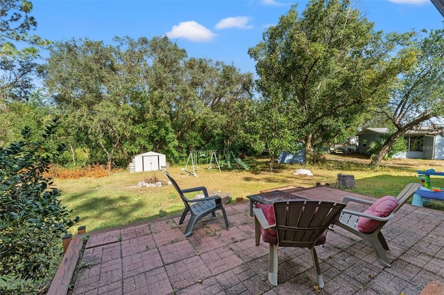 view of patio / terrace with a playground and a storage shed