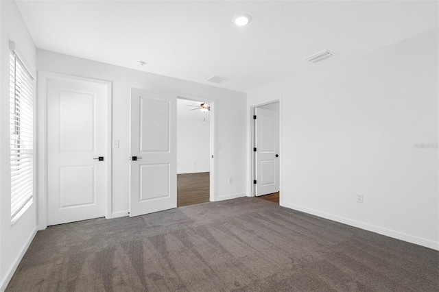 unfurnished bedroom with dark colored carpet