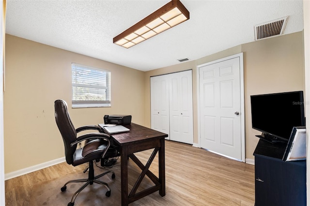 office area featuring a textured ceiling and light wood-type flooring