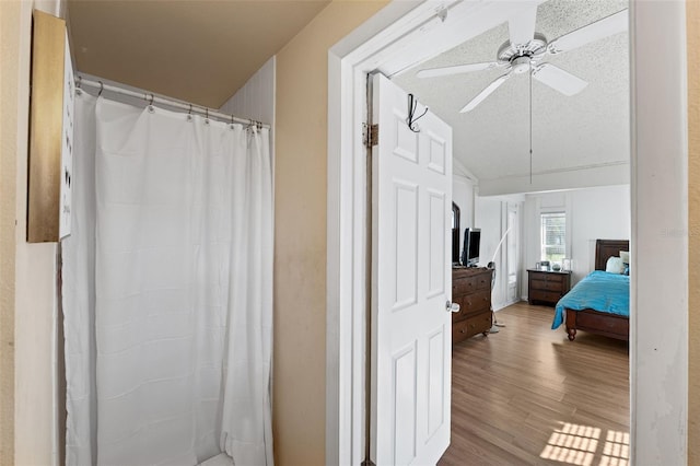 bathroom with ceiling fan, hardwood / wood-style floors, and a textured ceiling