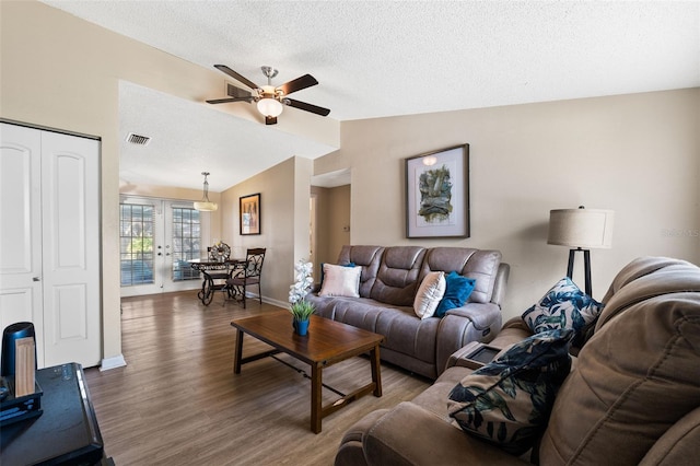 living room with ceiling fan, french doors, dark wood-type flooring, a textured ceiling, and vaulted ceiling