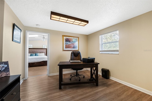 office area featuring ceiling fan, dark hardwood / wood-style flooring, and a textured ceiling