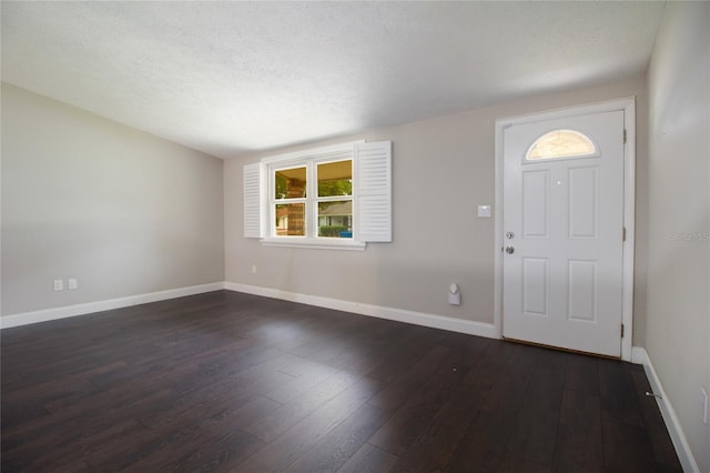 entrance foyer with dark hardwood / wood-style floors and a textured ceiling