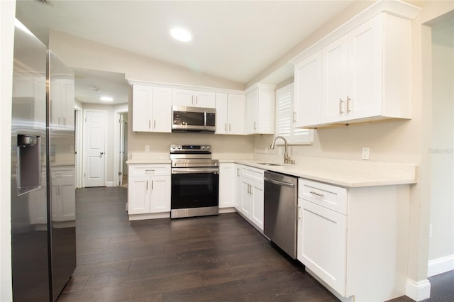 kitchen featuring sink, stainless steel appliances, dark hardwood / wood-style flooring, lofted ceiling, and white cabinets