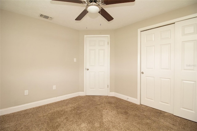 unfurnished bedroom with ceiling fan, a closet, carpet floors, and a textured ceiling