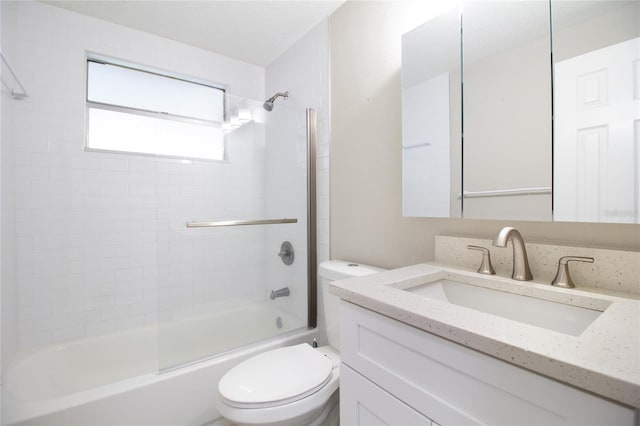 full bathroom with a textured ceiling, vanity, toilet, and tiled shower / bath