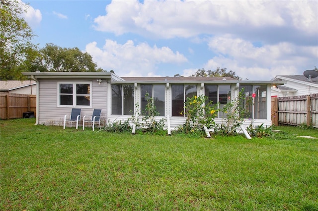 back of property featuring a sunroom and a yard