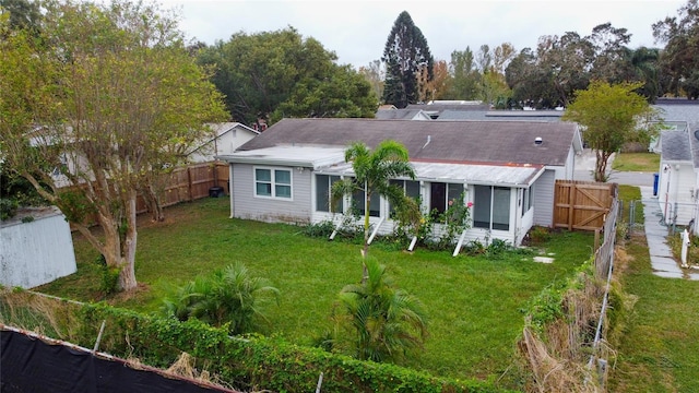 rear view of house featuring a yard