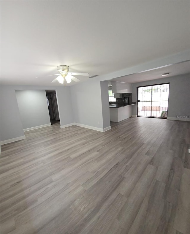 unfurnished living room with ceiling fan and light hardwood / wood-style floors