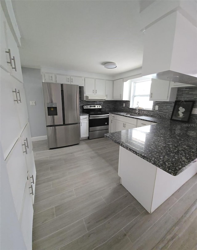 kitchen featuring kitchen peninsula, appliances with stainless steel finishes, light wood-type flooring, and white cabinets