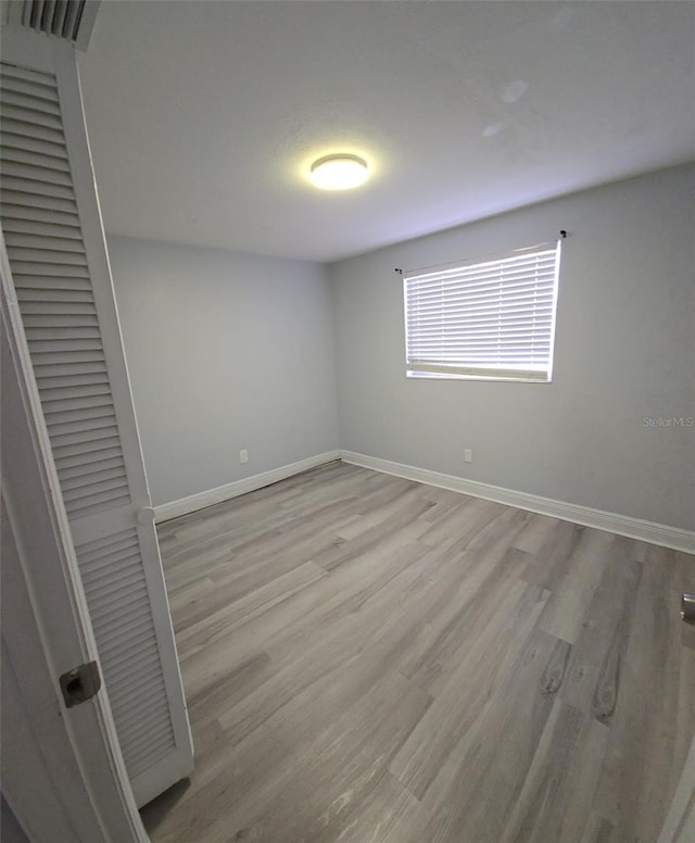 unfurnished bedroom with light hardwood / wood-style flooring and a closet