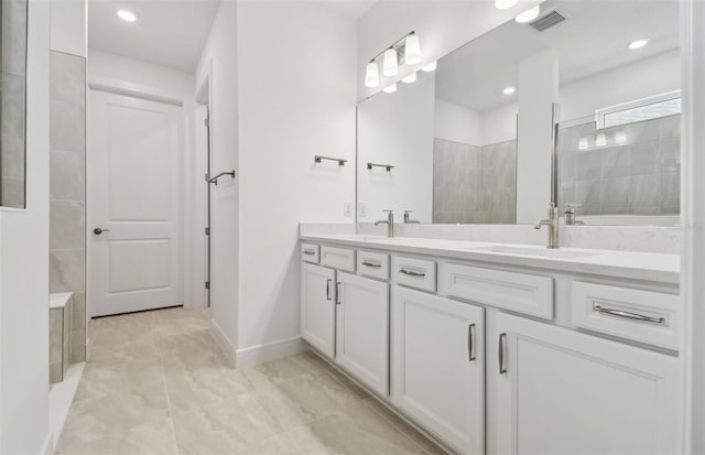 bathroom with tiled shower and vanity