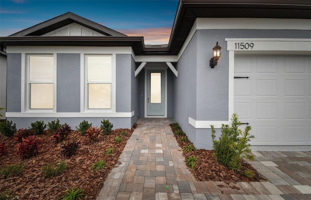 exterior entry at dusk with a garage