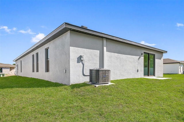 back of property with a lawn and cooling unit