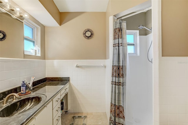 bathroom featuring tile patterned floors, vanity, tile walls, and walk in shower