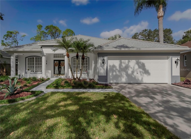 view of front facade featuring a garage, french doors, and a front lawn