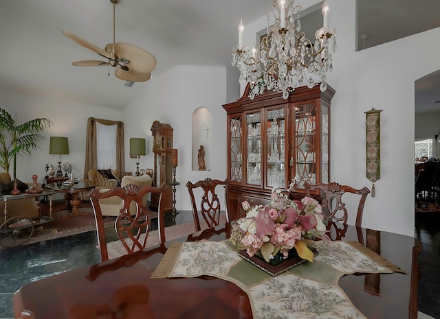 dining room featuring ceiling fan with notable chandelier and lofted ceiling