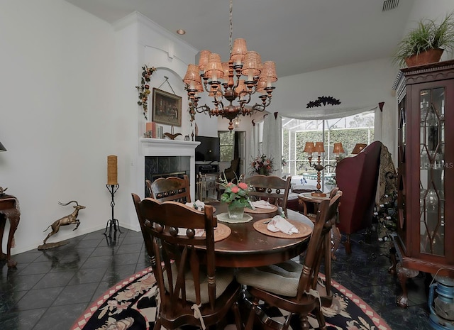 dining space with a fireplace, dark tile patterned floors, and a notable chandelier