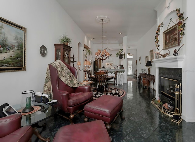 living room featuring a high end fireplace and a chandelier