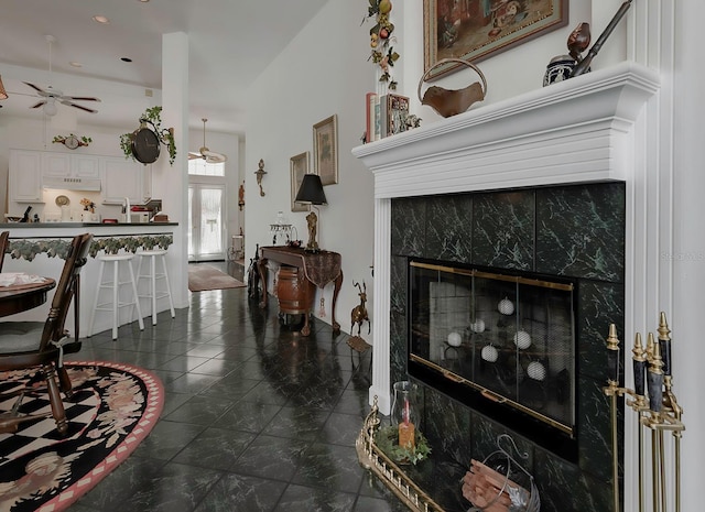 living room featuring ceiling fan and a fireplace