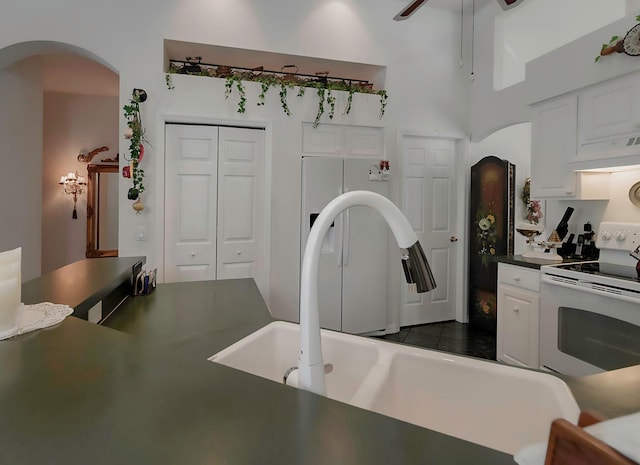 kitchen featuring white cabinetry, sink, a high ceiling, and white electric range