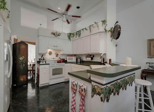 kitchen featuring kitchen peninsula, white cabinetry, sink, and white appliances