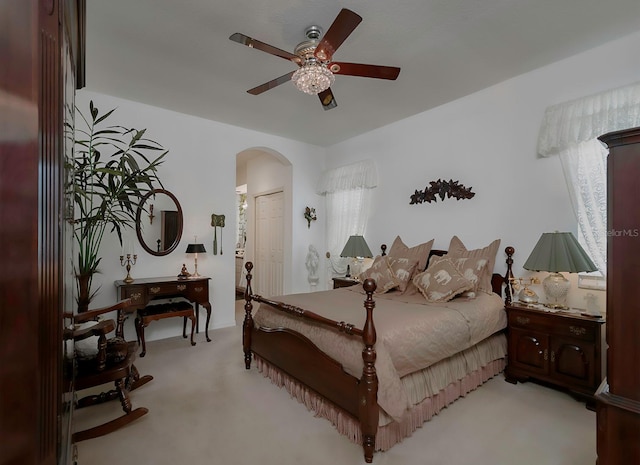 bedroom featuring ceiling fan, multiple windows, light carpet, and a closet