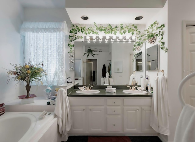 bathroom with vanity and tiled bath