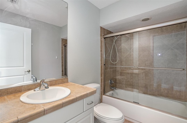 full bathroom featuring vanity, toilet, and bath / shower combo with glass door