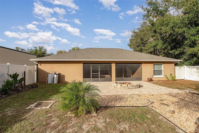 back of house featuring a yard, a patio, and an outdoor fire pit