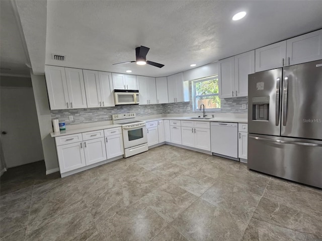 kitchen featuring ceiling fan, white cabinetry, white appliances, and sink