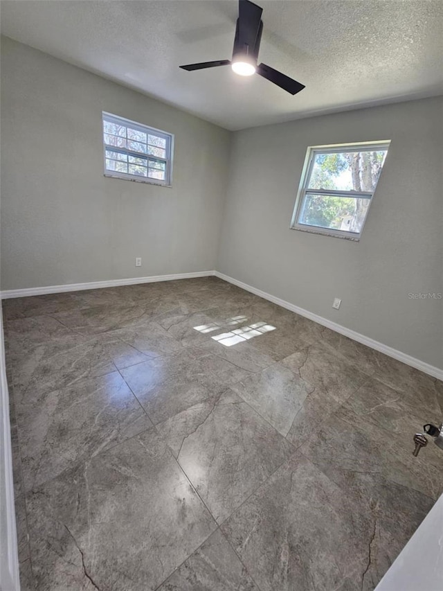 unfurnished room featuring ceiling fan and a textured ceiling