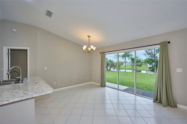 interior space featuring a water view, light tile patterned floors, sink, and vaulted ceiling