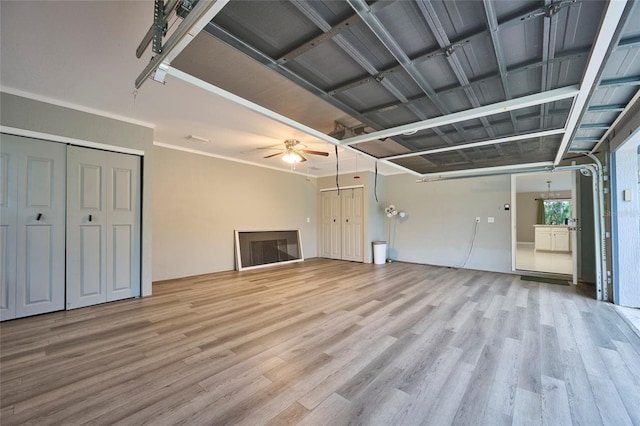 unfurnished living room with ceiling fan, wood-type flooring, and ornamental molding