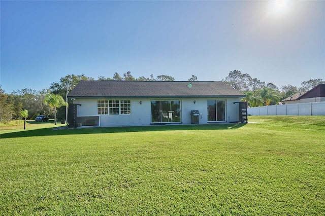 rear view of house featuring a lawn