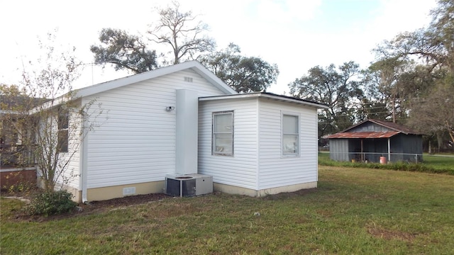 rear view of house with a lawn and central AC